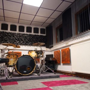 Foto von Aufnahmeraum 1 im StudioCarbon Tonstudio - Wiener Neudorf bei Mödling. Zu sehen sind ein Schlagzeug sowie einige Gitarren an Wandhalterungen