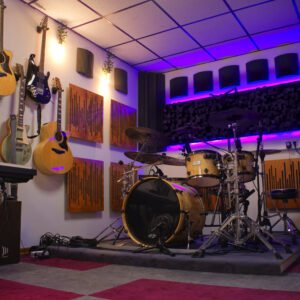 Foto von Aufnahmeraum 1 im StudioCarbon Tonstudio - Wiener Neudorf bei Mödling. Zu sehen sind ein Schlagzeug sowie einige Gitarren an Wandhalterungen